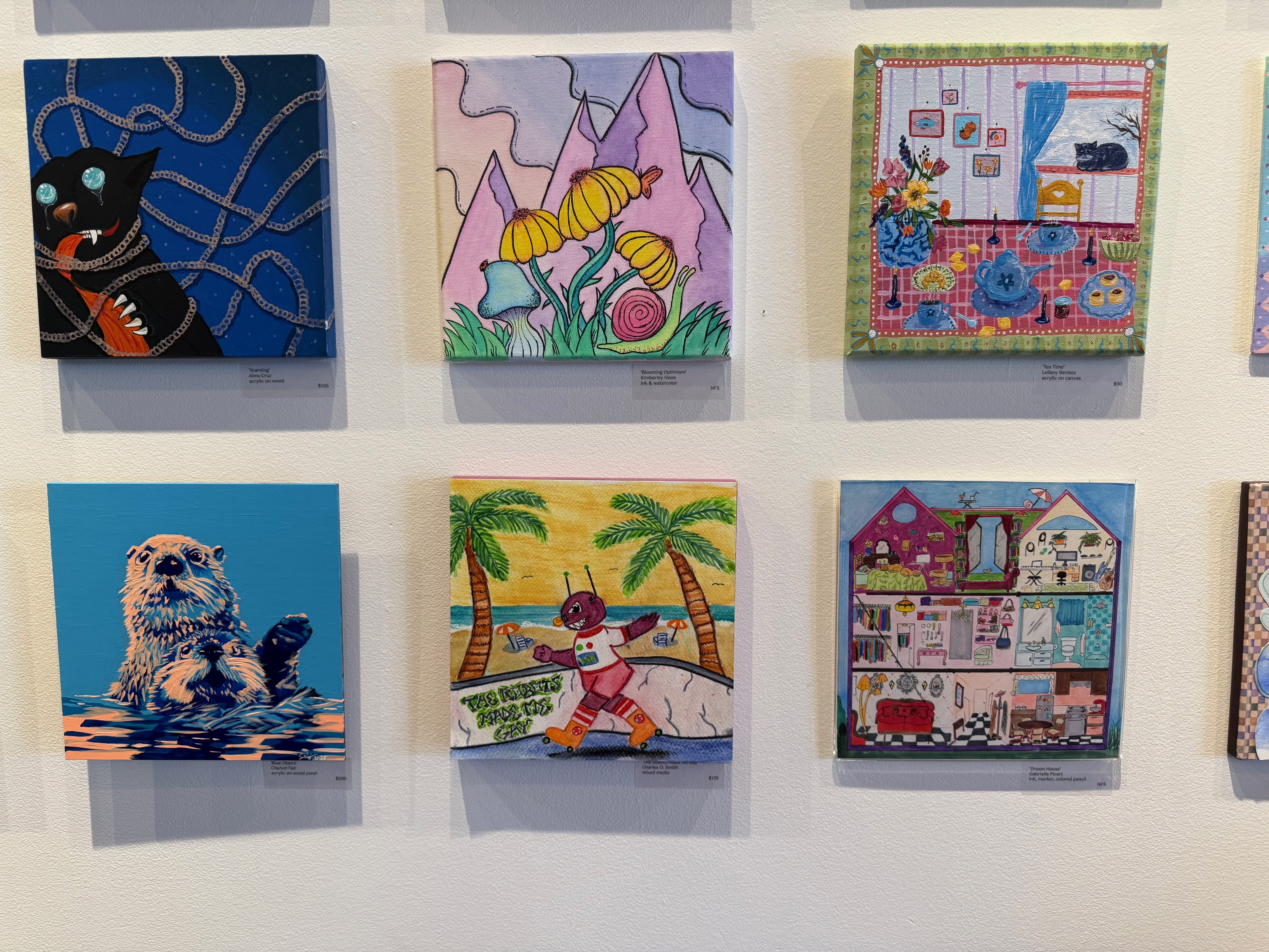 My robot drawing hanging in a grid of 6 8"x8" pieces on the wall of the Tamper Room. Other images include a crazed cat tangled in string, fantastical flowers and musrooms, a cozy tea-room interior with a cat in the window, two otters frolicking in the water, and a doll house interior.